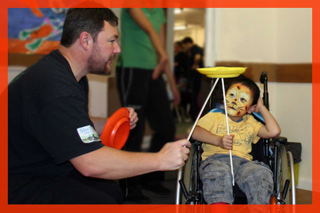 Peter Hurley passing a spinning plate to a young boy using a wheelchair in Sheffield