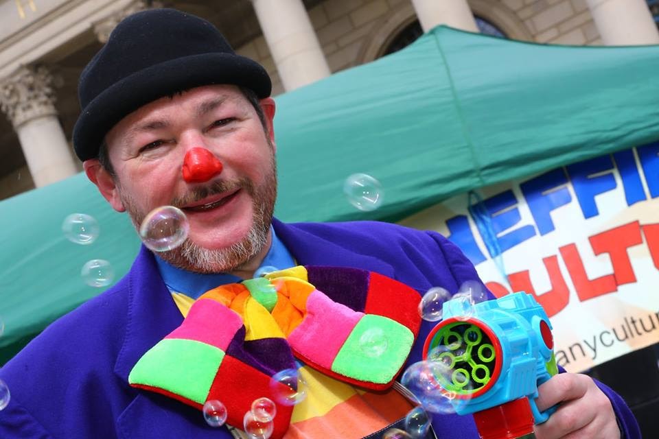 Curley Wurley Clown blowing bubbles at Sheffield City Centre event.