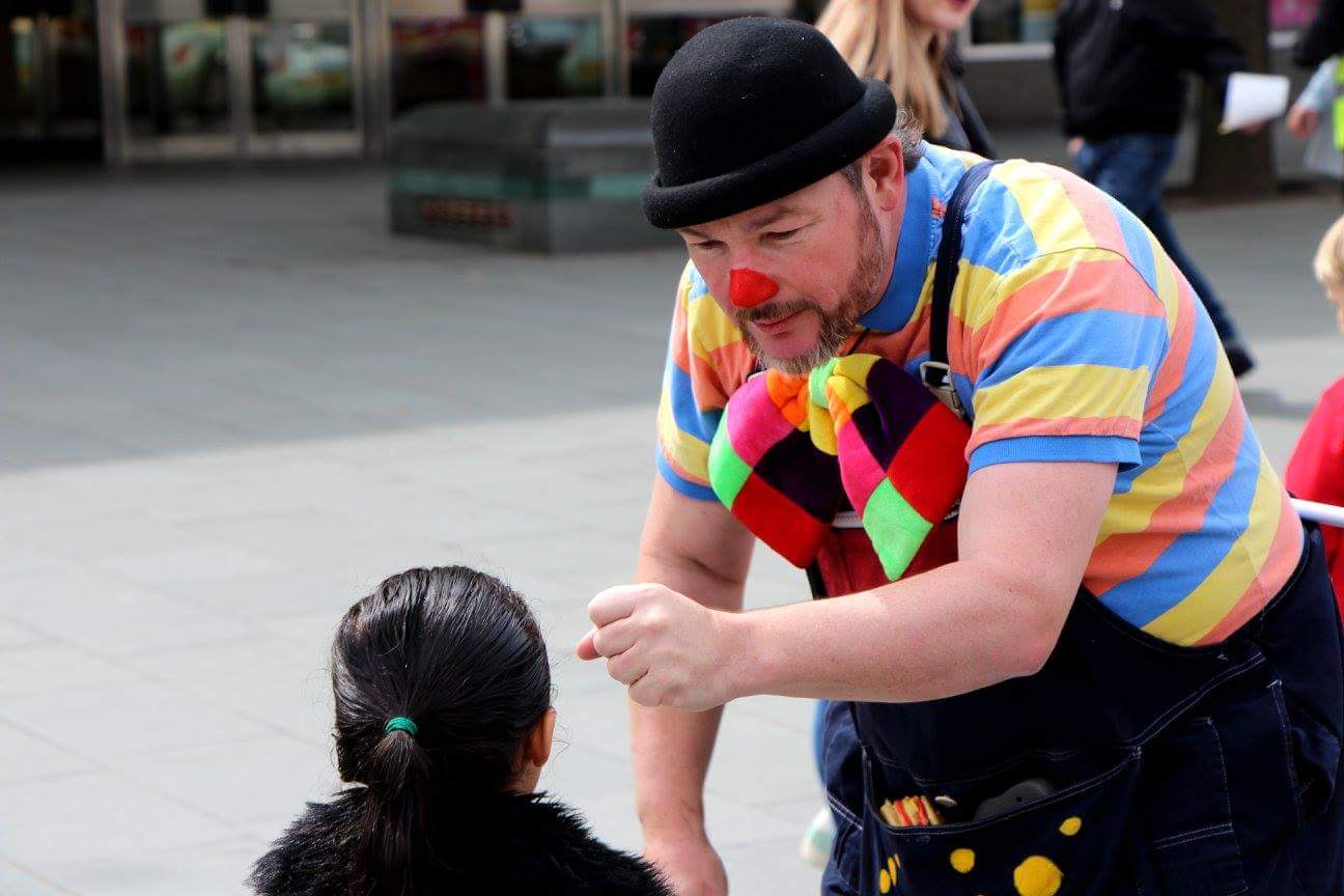 Curley Wurley Clown entertaining a girl in Sheffield City Centre