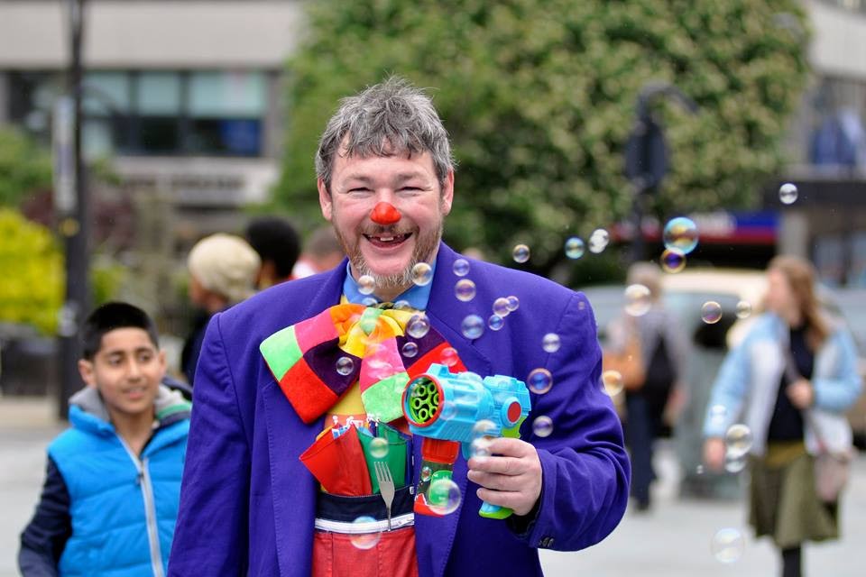 Curley Wurley Clown blowing bubbles with bubble gun