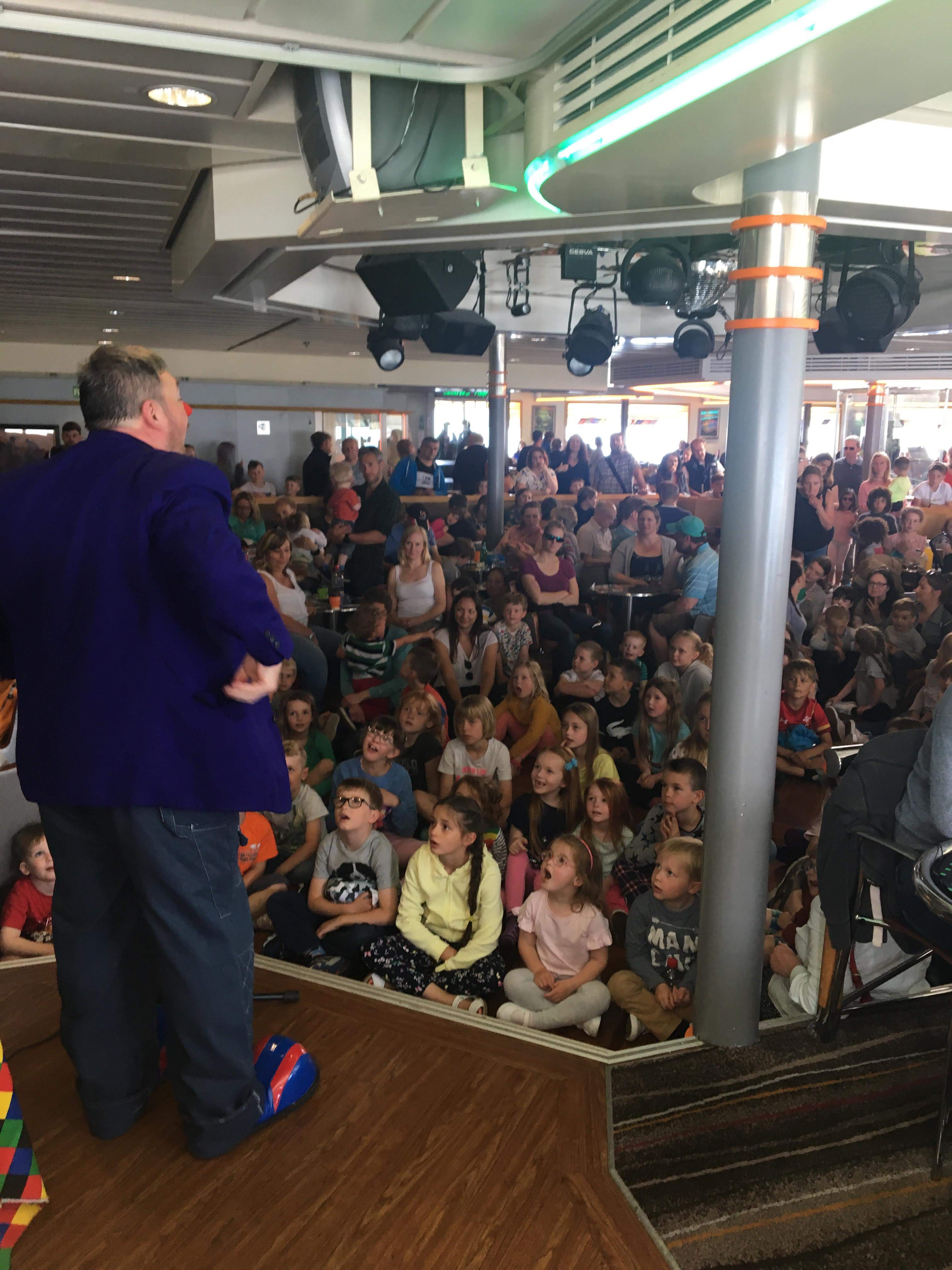 Curley Wurley Clown performing to a large crowd onboard Brittany Ferries